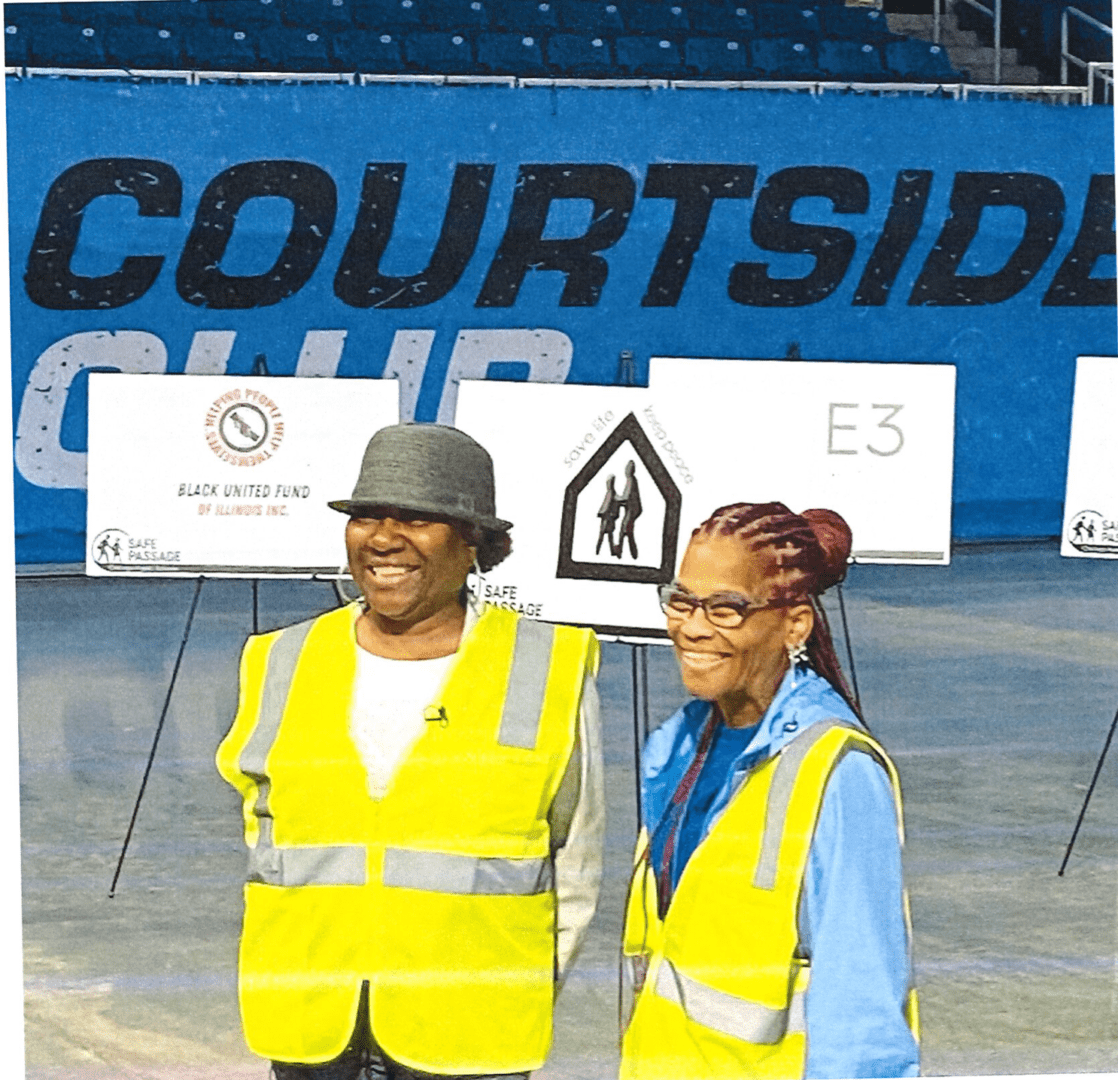 A man and a woman wearing safety jackets in a stadium